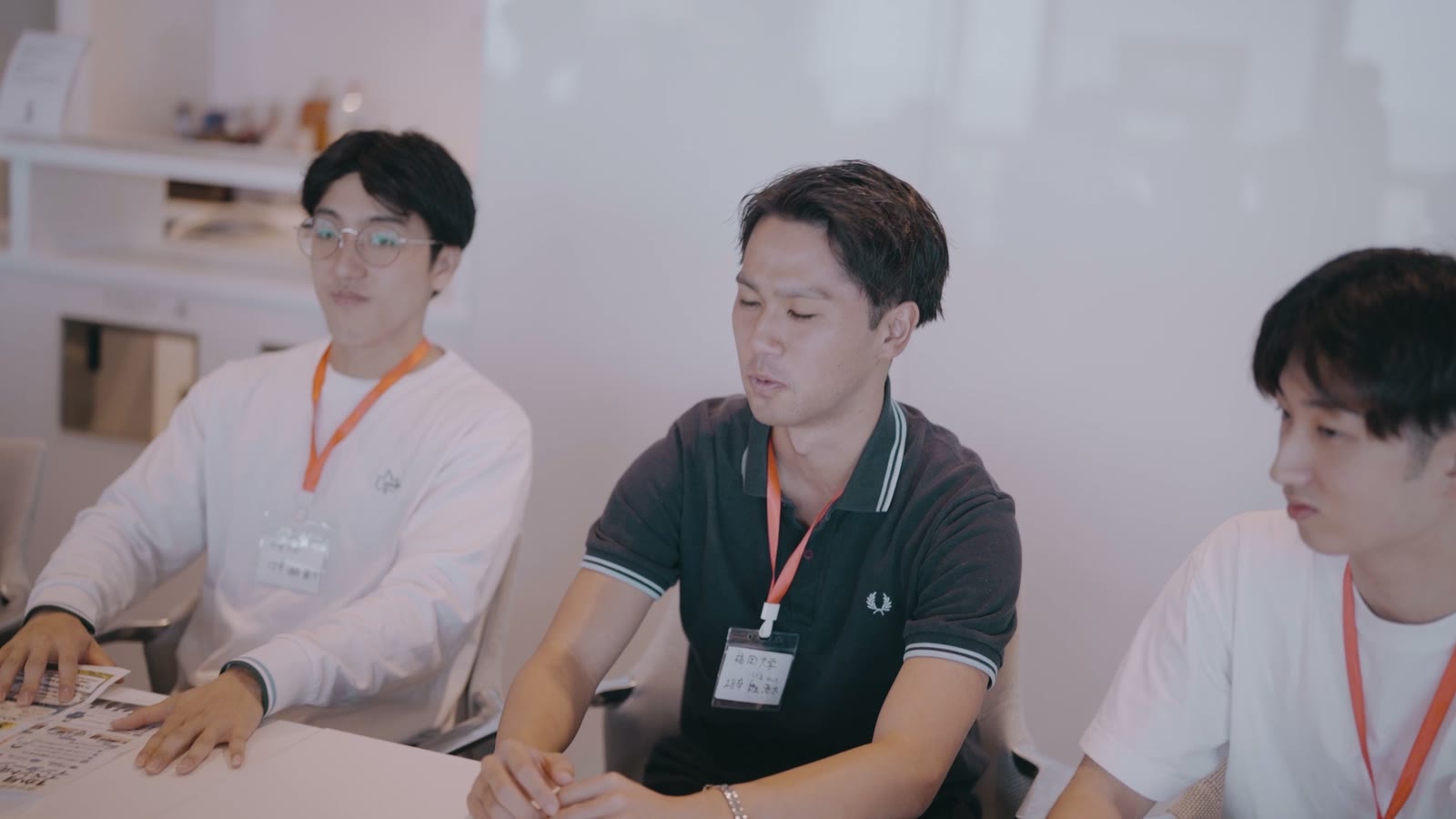 テーブルを囲んで話す学生と企業の担当者